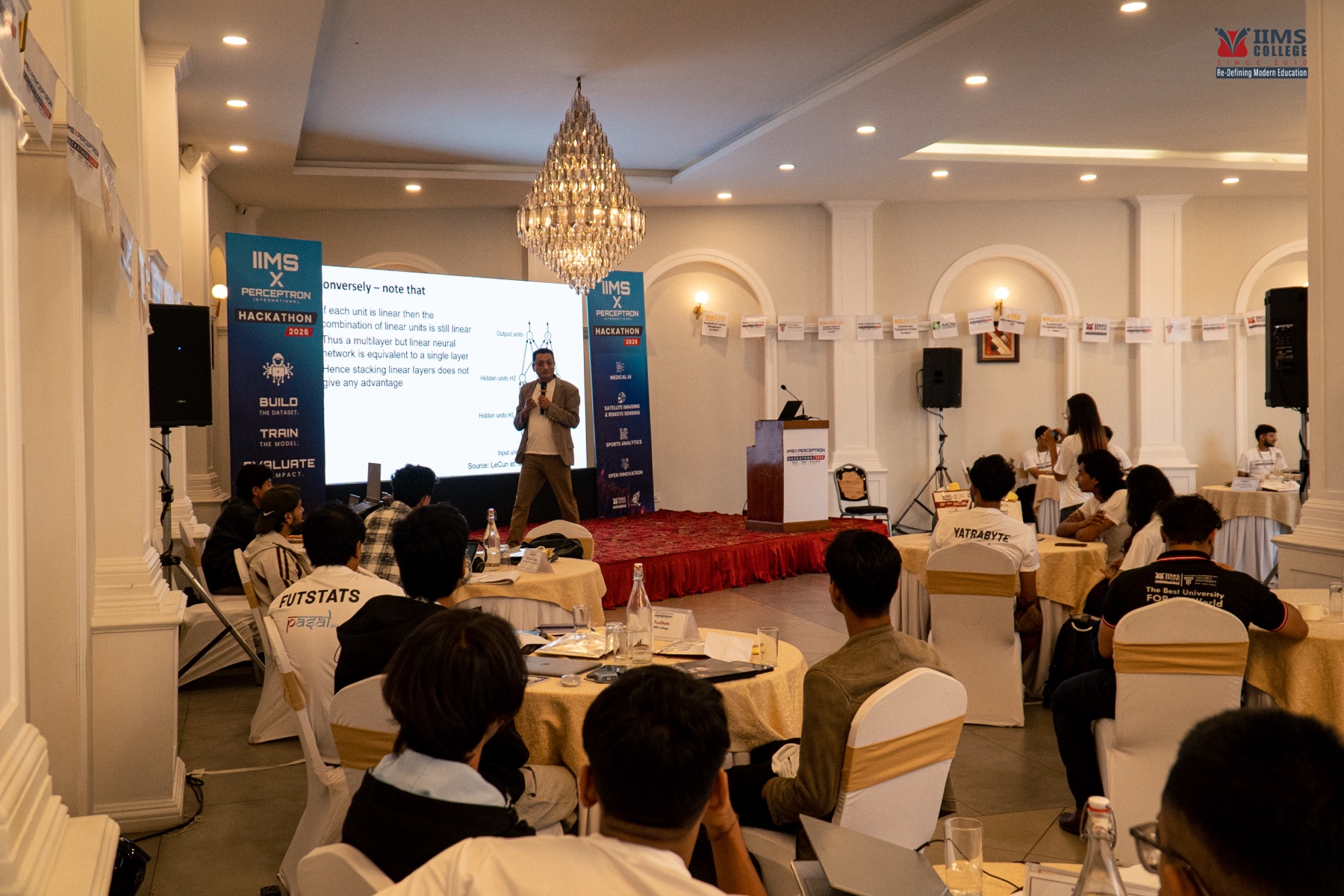 An expert speaker presenting to participants beneath the event's challenge-track banners