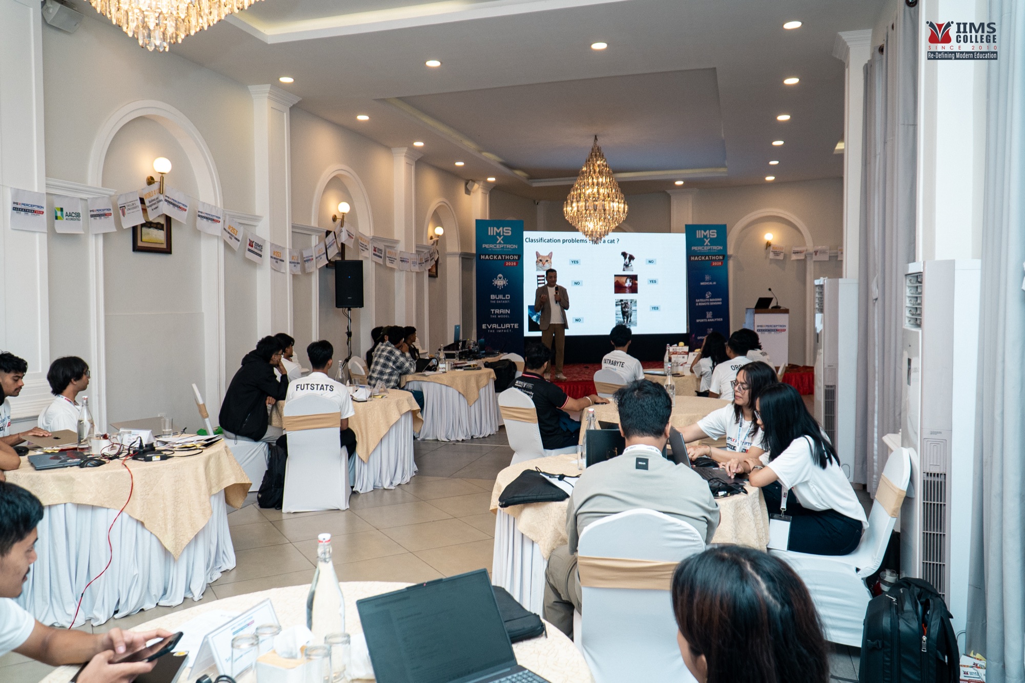 A room-wide view of teams and an expert session at the Perceptron International Hackathon 2026